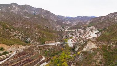 Büyük Tujunga Köprüsü ve Josephine Tepesi 'nin havadan yörüngesi Angeles Ulusal Ormanı, Kaliforniya' da canlı sonbahar yeşillikleri ve görkemli dağ manzaraları sergiliyor..