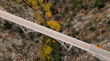 Büyük Tujunga Narrows Köprüsü 'nün Angeles Ormanı Otoyolu, Angeles Ulusal Ormanı, Kaliforniya' daki hava gösteriminde canlı sonbahar yaprakları ve görkemli dağ manzaraları sergilenmektedir..