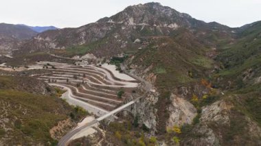 Los Angeles Ulusal Ormanı, Kaliforniya 'daki Büyük Tujunga Köprüsü ve Josephine Tepesi' nin hava manzarasında canlı sonbahar yaprakları ve görkemli dağ manzaraları sergilenmektedir..
