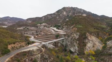 Los Angeles Ulusal Ormanı, Kaliforniya 'daki Büyük Tujunga Köprüsü ve Josephine Tepesi' nin hava manzarasında canlı sonbahar yaprakları ve görkemli dağ manzaraları sergilenmektedir..