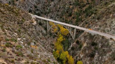 Angeles Orman Yolu boyunca uzanan Büyük Tujunga Narrows Köprüsü Havalimanı, Angeles Ulusal Ormanı, Kaliforniya, canlı sonbahar yeşillikleri ve görkemli dağ manzaraları sergilenmektedir..