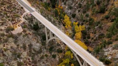 Angeles Orman Yolu boyunca uzanan Büyük Tujunga Narrows Köprüsü Havalimanı, Angeles Ulusal Ormanı, Kaliforniya, canlı sonbahar yeşillikleri ve görkemli dağ manzaraları sergilenmektedir..