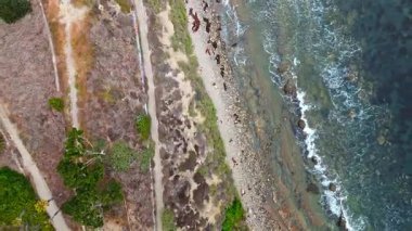 Los Angeles, Kaliforniya 'daki Point Fermin' in alçak hava manzarası, engebeli okyanus kayalıkları, çarpan dalgalar ve karamsar bulutlu kıyı manzarası