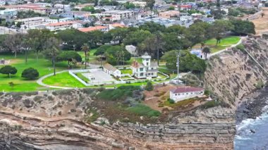 Los Angeles, Kaliforniya 'daki Point Fermin' in alçak hava manzarası, engebeli okyanus kayalıkları, çarpan dalgalar ve karamsar bulutlu kıyı manzarası