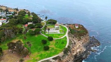 Los Angeles, Kaliforniya 'daki Point Fermin' in alçak hava manzarası, engebeli okyanus kayalıkları, çarpan dalgalar ve karamsar bulutlu kıyı manzarası