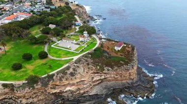 Los Angeles, Kaliforniya 'daki Point Fermin' in alçak hava manzarası, engebeli okyanus kayalıkları, çarpan dalgalar ve karamsar bulutlu kıyı manzarası