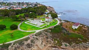 Los Angeles, Kaliforniya 'daki Point Fermin' in alçak hava manzarası, engebeli okyanus kayalıkları, çarpan dalgalar ve karamsar bulutlu kıyı manzarası