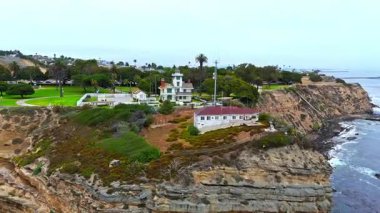 Los Angeles, Kaliforniya 'daki Point Fermin' in alçak hava manzarası, engebeli okyanus kayalıkları, çarpan dalgalar ve karamsar bulutlu kıyı manzarası