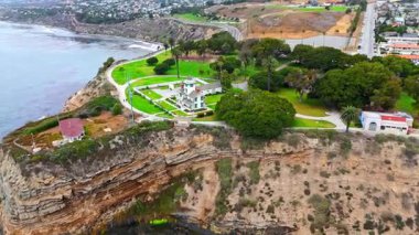 Los Angeles, Kaliforniya 'daki Point Fermin' in alçak hava manzarası, engebeli okyanus kayalıkları, çarpan dalgalar ve karamsar bulutlu kıyı manzarası