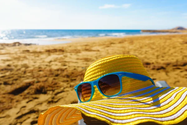휴일에는 해변에서 해변의 모래사장에 선글라스와 밀짚모자 — 스톡 사진