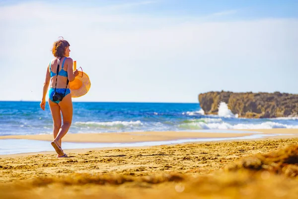 旅行自由概念 穿着比基尼的成熟女性游客 带着相机在海滩上散步 日光浴 享受暑假 — 图库照片