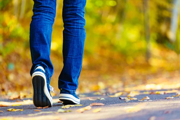 stock image Person wearing casual sneakers shoes and blue jeans trousers walking outdoor. Stylish urban fashion details.