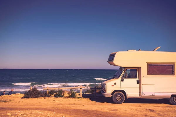 stock image Camper, recreational vehicle on mediterranean coast in Spain. Camping on nature beach. Holidays and travel in motor home.
