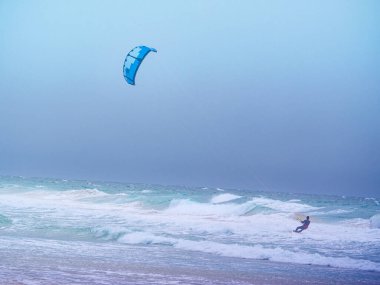 Kiteboarding. kite surfer rides the waves, Tarifa Spain. Sports activity. Kitesurfing action. clipart