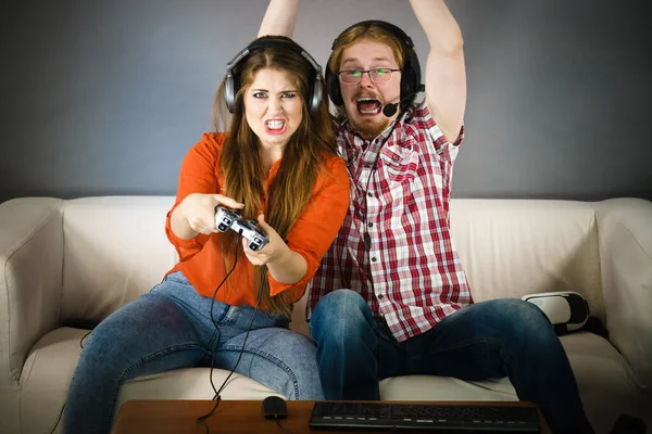 カップルが一緒にビデオゲームをプレイすることによって余暇時間を楽しんで 男と女はゲームによって感情的である — ストック写真