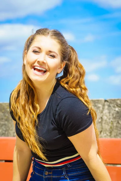 幸せな十代の女性は彼女の余暇時間を楽しんでいる 背景に空を背に長い茶色の髪を持つ女性 — ストック写真