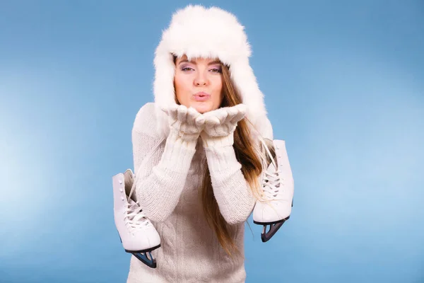 冬のスポーツの活動の概念 魅力的女の子作るキス ジェスチャー暖かい服を着て アイス スケート 毛皮のような帽子 青い背景のスタジオ撮影 — ストック写真