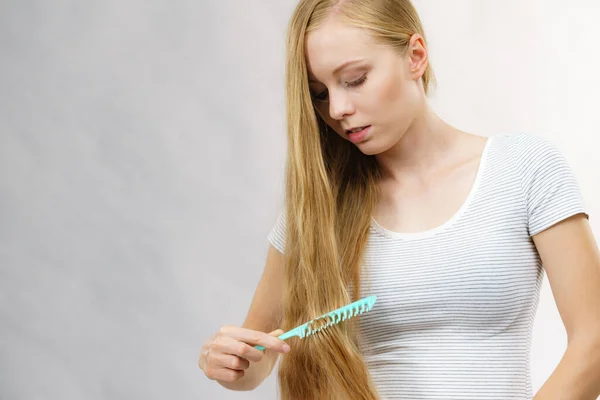 Genç Bir Kadın Uzun Sağlıklı Sarı Saçlarını Tarıyor Tarak Kullanıyor — Stok fotoğraf
