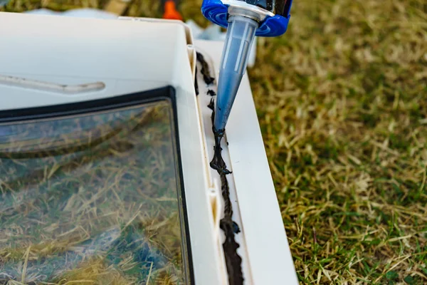 屋根のキャラバン窓にシリコーン銃でシリコーンシーラントを適用する者の手 — ストック写真