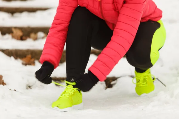 冬季运动时尚的概念 女人们把运动鞋绑在雪地里 把鞋子绑在外面锻炼 — 图库照片