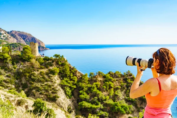 海辺の崖 地中海沿岸の風景からの旅行写真を撮るカメラを持つ観光客の女性 夏休み旅行 — ストック写真