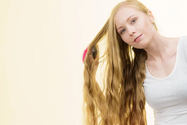 用刷子梳理长发的金发姑娘 照顾的女孩使她的发型焕然一新 理发概念 — 图库照片