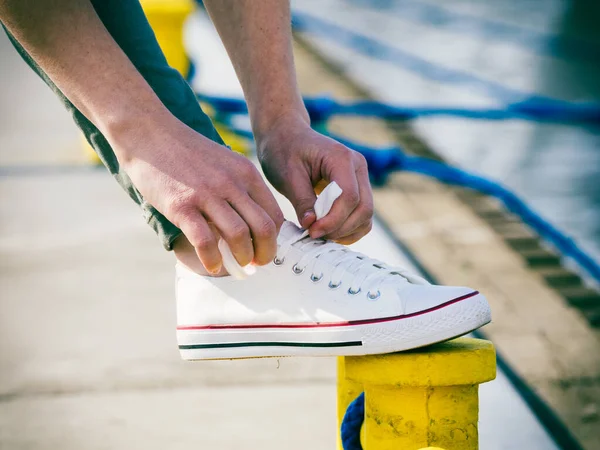 Человек Приспосабливается Завязывает Шнурки Белых Кроссовках Повседневная Обувь Жёлтой Булавке — стоковое фото