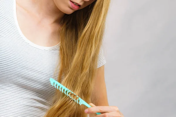 Молодая Женщина Расчесывает Длинные Здоровые Светлые Волосы Используя Расческу — стоковое фото