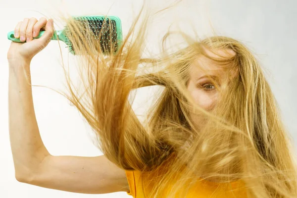 Blondýnka Dlouhé Rozcuchané Vlasy Drží Velký Kartáč Rozmotává Kartáčuje Vlasy — Stock fotografie