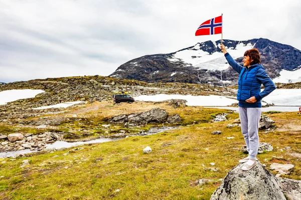 妇女在山上高举挪威国旗 房顶上有独木舟 挪威Sognefjellet国家旅游风景线55 — 图库照片
