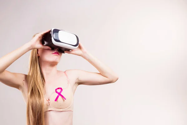 戴着粉色缎带和虚拟现实护目镜的女人戴着耳机和盒子 新一代和乳腺癌意识 — 图库照片
