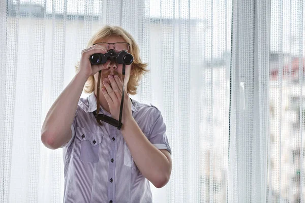 Junger Erwachsener Mann Spioniert Nachbarn Mit Fernglas Aus — Stockfoto