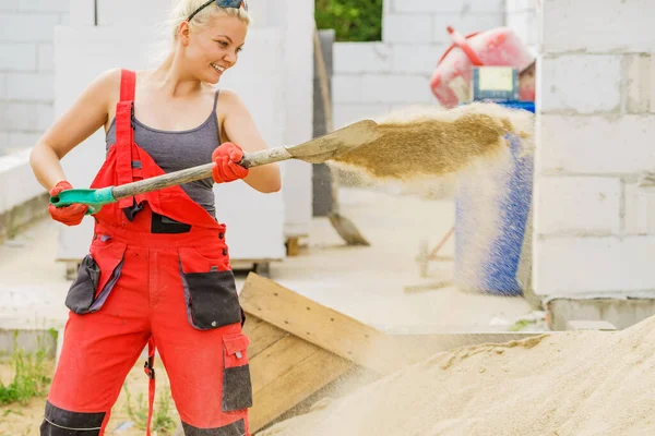 妇女在工地辛勤劳作 用铲子挖沙土 部分建造了新住房的早期阶段 — 图库照片