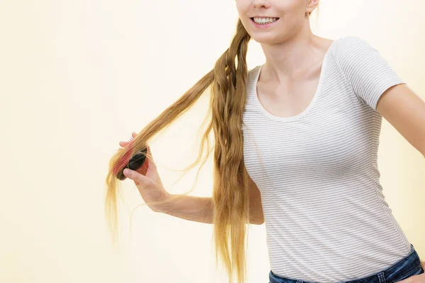 用刷子梳理长发的金发姑娘 照顾的女孩使她的发型焕然一新 理发概念 — 图库照片