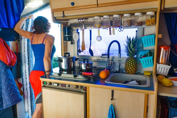 キャラバン内の女性は キッチンエリアから外を見る キャンパーバンで料理 モーターホームと冒険 ヴァンライフライフスタイル — ストック写真