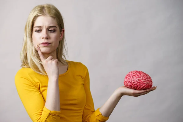 Молодая Женщина Студентка Думает Решении Проблемы Держа Руках Фальшивый Мозг — стоковое фото