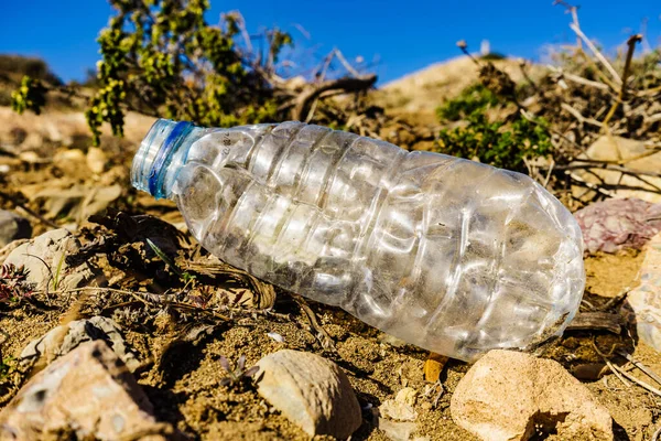 Plastic empty water bottle abandoned on nature. Environmental pollution global ecological problem. Earth ecology.