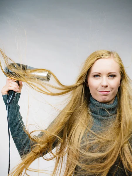 金发女人把她的长发剪成这样 吹乱头发的女人拿着吹风机 头发配饰 — 图库照片