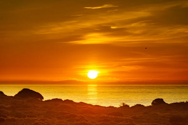 Sunrise over sea. Bright sun under the water surface. Sun up above horizon. Morning seascape.