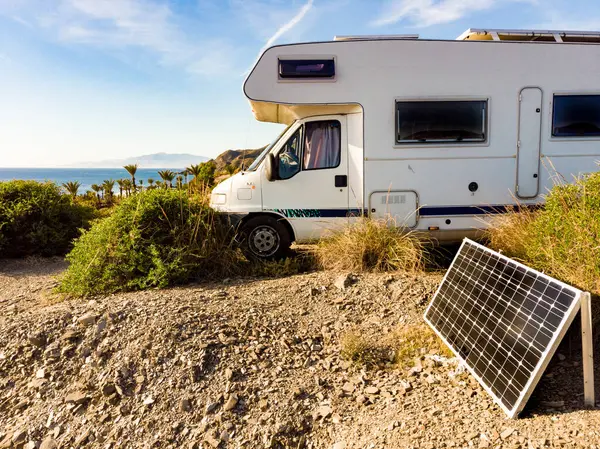 Caravan with portable solar panel camping on sea coast. Holidays in winter time. Mediterranean region of Villaricos, Almeria, eastern Andalusia, Spain.