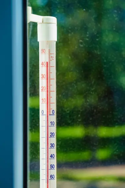 窗户上的温度计在外面的热浪中显示出高温 夏季气温 气候变化 免版税图库图片