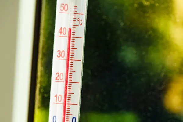 窓の温度計は外の熱波の間の高温を示しています 夏の気温気候変動 ストック画像
