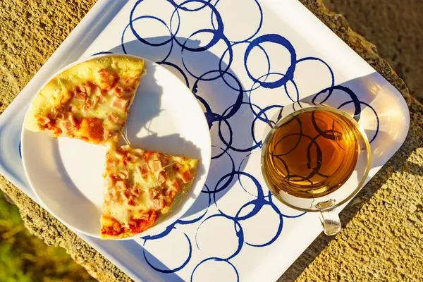 プレート上のティーマグカップとピザのスライス 外の食事 トップダウンビュー ストック写真
