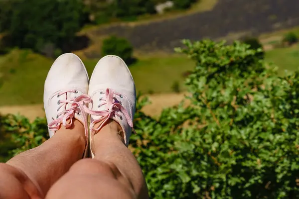 雌性脚踏着运动鞋 与绿色夏季的天性相违背 积极的生活方式 免版税图库照片