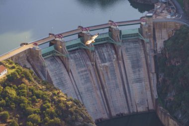 Spanish Saucelle Dam on Douro river. Border between Portugal and Spain. National Park. View from portuguese Penedo Durao lookout. clipart