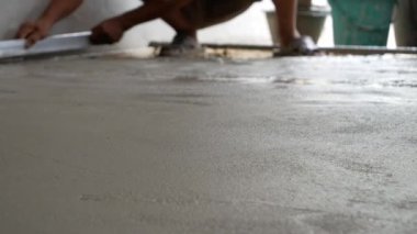 Becerikli adam beton zemini yıkıyor.