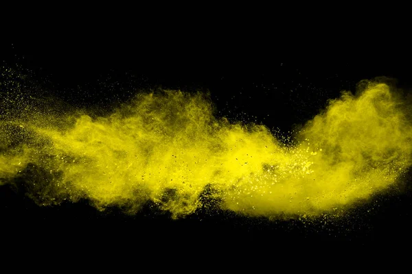 Yellow dust particle explosion on black background.Yellow powder  splash.