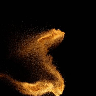 Golden sand explosion isolated on black background. Colored sand splash.