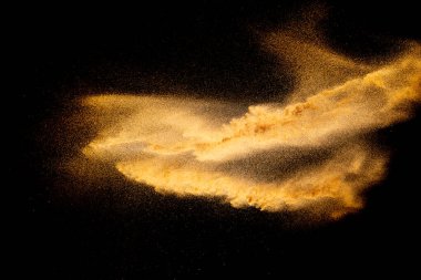 Kuru nehir kum patlaması. Kahverengi renk kum siyah arka plana sıçrar..