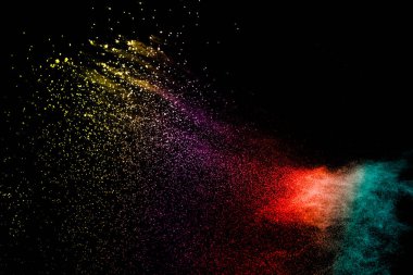 Explosion of colorful Holi powder on black background. Vibrant color dust particles textured background.